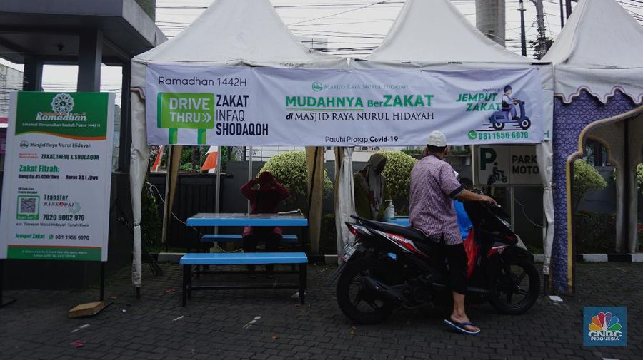 Warga menunaikan zakat fitrah dalam acara ulan suci Ramadan 1442 Hijriah di Gerai Zakat Infaq dan Shodaqoh drive thru di Masjid Nurul Hidayah, Jakarta, Selasa (11/5/2021). (վ/Tri Susilo)