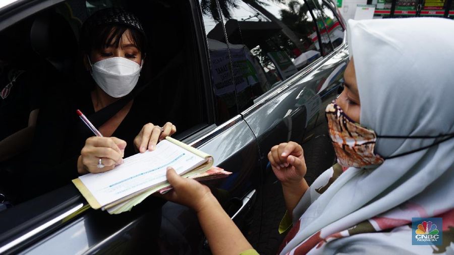 Warga menunaikan zakat fitrah dalam acara ulan suci Ramadan 1442 Hijriah di Gerai Zakat Infaq dan Shodaqoh drive thru di Masjid Nurul Hidayah, Jakarta, Selasa (11/5/2021). (CNBC Indonesia/Tri Susilo)