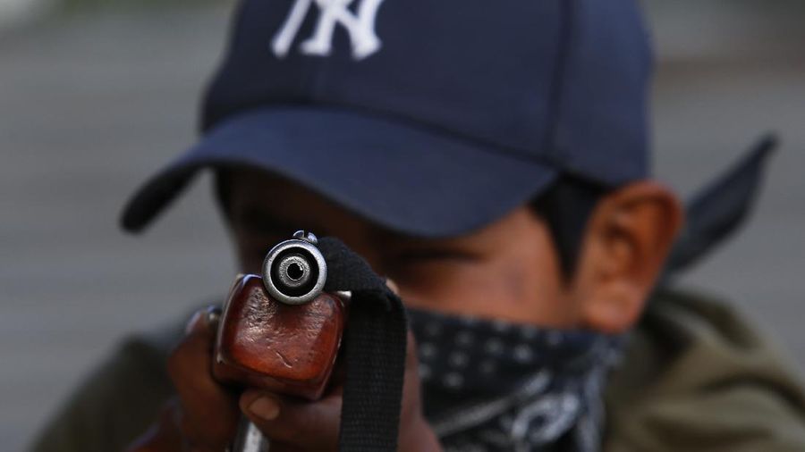 Luis Gustavo Morales, the 15-year-old son of a community policeman, practices his aim with a fake weapon during a display set up for the media to attract the federal government’s attention to the dangers of organized crime which his town negotiates daily in Ayahualtempa, Guerrero state, Mexico, Wednesday, April 28, 2021. Luis Gustavo's father Luis Morales said that at first it made him sad to train his son to defend the town, but now he's proud of him because he will know how. (AP Photo/Marco Ugarte)