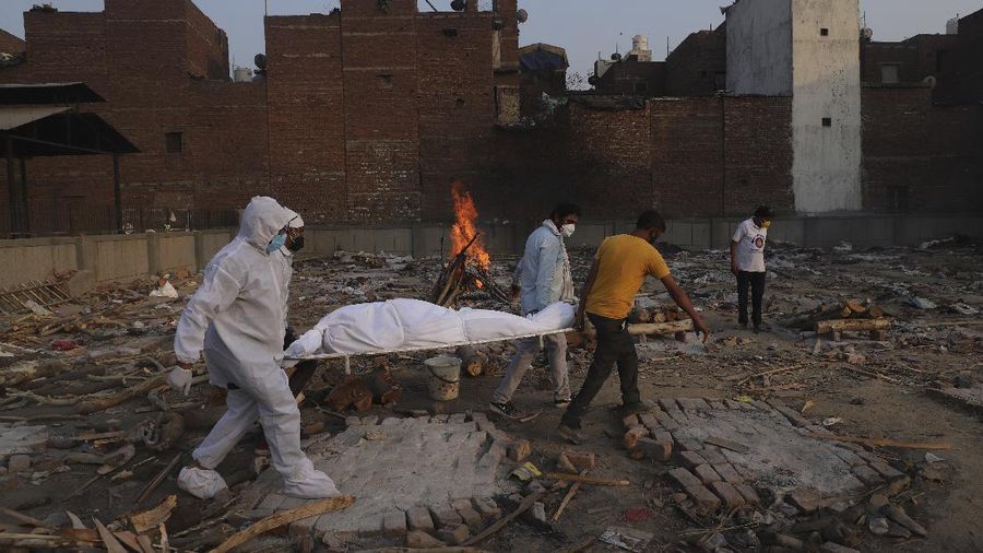 Family members and volunteers carry the body of a COVID-19 victim for cremation in New Delhi, India, Tuesday, May 11, 2021. (AP Photo/Amit Sharma)