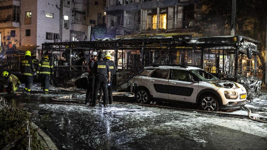 An Israeli firefighter works at the site where a rocket fired from the Gaza Strip, hit the central Israeli town of Holon, near Tel Aviv, Tuesday, May 11, 2021. A confrontation between Israel and Hamas sparked by weeks of tensions in contested Jerusalem escalated Tuesday as Israel unleashed new airstrikes on Gaza while militants barraged Israel with hundreds of rockets. (AP Photo/Heidi Levine)