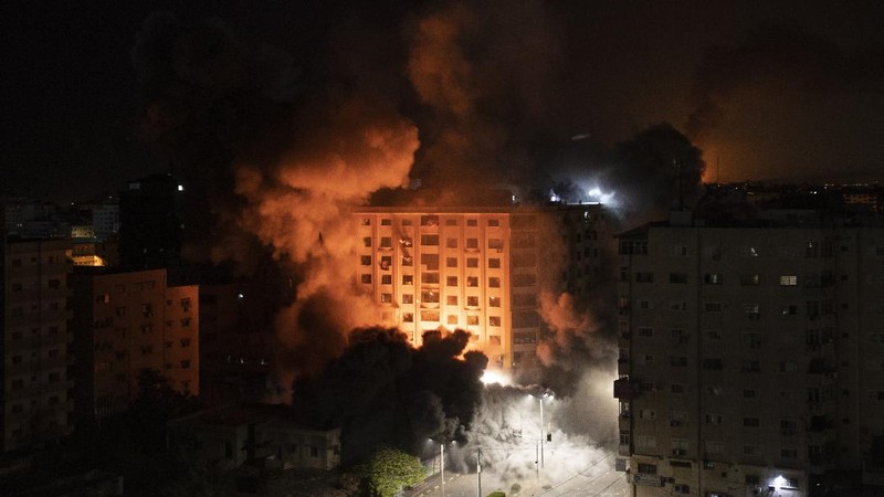Smoke caused by Israeli airstrikes are seen at a residential building in Gaza City, early Wednesday, May 12, 2021. (AP Photo/Khalil Hamra)