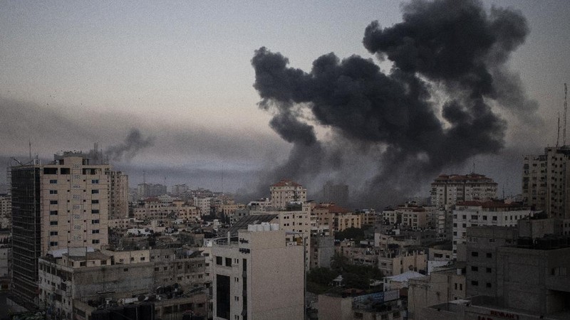 Smoke caused by Israeli airstrikes are seen at a residential building in Gaza City, early Wednesday, May 12, 2021. (AP Photo/Khalil Hamra)