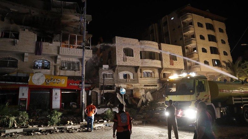 Smoke caused by Israeli airstrikes are seen at a residential building in Gaza City, early Wednesday, May 12, 2021. (AP Photo/Khalil Hamra)