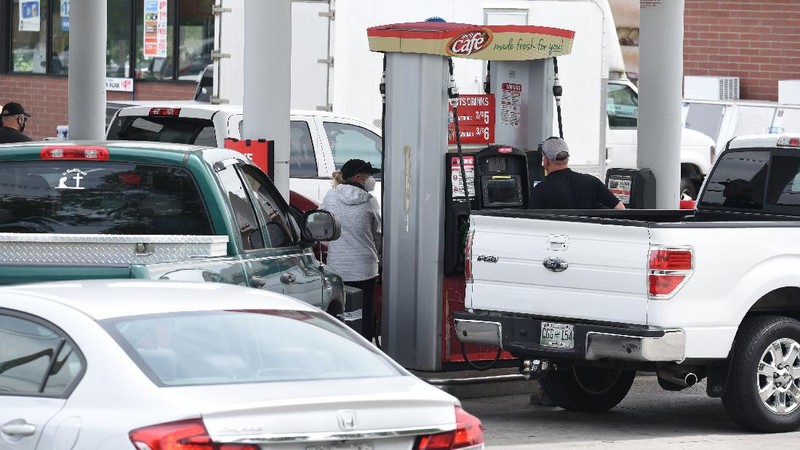 Customers fill up their automobiles and gas containers with fuel at the Circle K on Wednesday, May 12, 2021 in Raleigh, N.C.  Several gas stations in the Southeast reported running out of fuel, primarily because of what analysts say is unwarranted panic-buying among drivers, as the shutdown of a major pipeline by hackers entered its fifth day.  (Robert Willett/The News & Observer via AP)