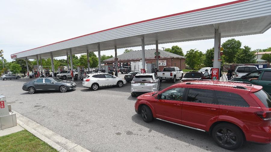 Customers fill up their automobiles and gas containers with fuel at the Circle K on Wednesday, May 12, 2021 in Raleigh, N.C.  Several gas stations in the Southeast reported running out of fuel, primarily because of what analysts say is unwarranted panic-buying among drivers, as the shutdown of a major pipeline by hackers entered its fifth day.  (Robert Willett/The News & Observer via AP)
