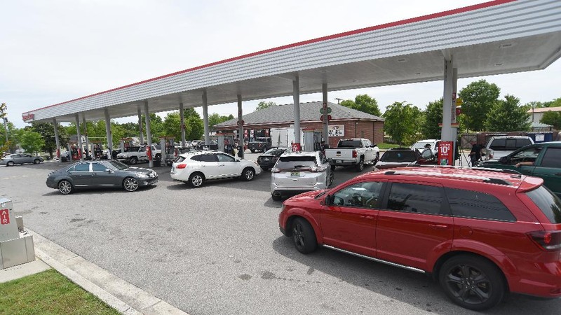 Customers fill up their automobiles and gas containers with fuel at the Circle K on Wednesday, May 12, 2021 in Raleigh, N.C.  Several gas stations in the Southeast reported running out of fuel, primarily because of what analysts say is unwarranted panic-buying among drivers, as the shutdown of a major pipeline by hackers entered its fifth day.  (Robert Willett/The News & Observer via AP)