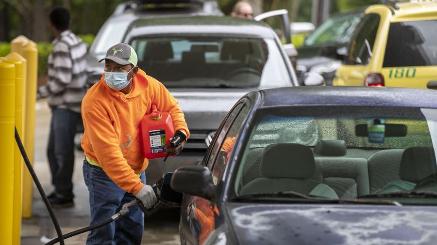 Customers fill up their automobiles and gas containers with fuel at the Circle K on Wednesday, May 12, 2021 in Raleigh, N.C.  Several gas stations in the Southeast reported running out of fuel, primarily because of what analysts say is unwarranted panic-buying among drivers, as the shutdown of a major pipeline by hackers entered its fifth day.  (Robert Willett/The News & Observer via AP)