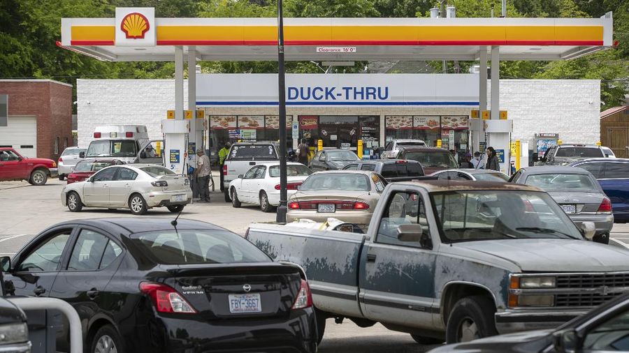 Customers fill up their automobiles and gas containers with fuel at the Circle K on Wednesday, May 12, 2021 in Raleigh, N.C.  Several gas stations in the Southeast reported running out of fuel, primarily because of what analysts say is unwarranted panic-buying among drivers, as the shutdown of a major pipeline by hackers entered its fifth day.  (Robert Willett/The News & Observer via AP)