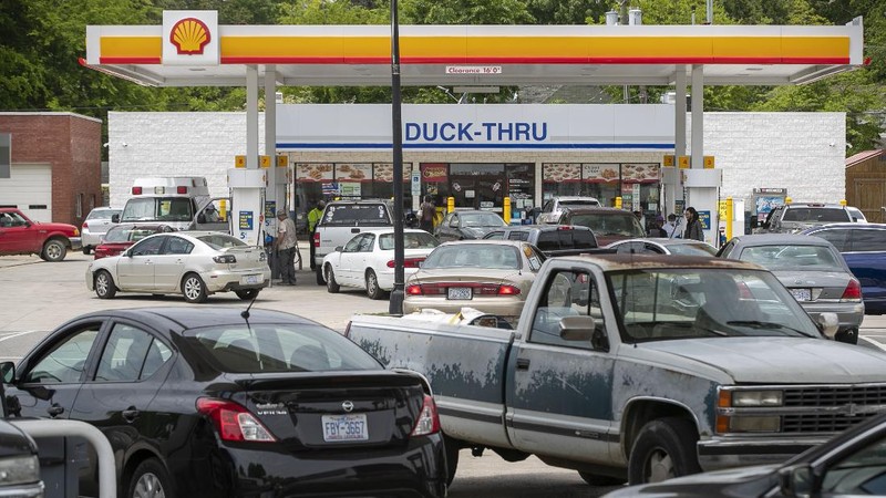 Customers fill up their automobiles and gas containers with fuel at the Circle K on Wednesday, May 12, 2021 in Raleigh, N.C.  Several gas stations in the Southeast reported running out of fuel, primarily because of what analysts say is unwarranted panic-buying among drivers, as the shutdown of a major pipeline by hackers entered its fifth day.  (Robert Willett/The News & Observer via AP)
