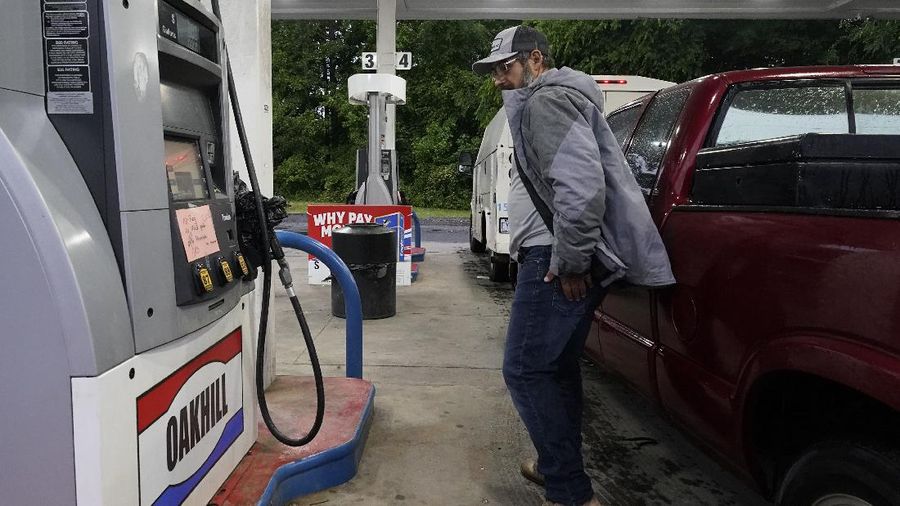 Customers fill up their automobiles and gas containers with fuel at the Circle K on Wednesday, May 12, 2021 in Raleigh, N.C.  Several gas stations in the Southeast reported running out of fuel, primarily because of what analysts say is unwarranted panic-buying among drivers, as the shutdown of a major pipeline by hackers entered its fifth day.  (Robert Willett/The News & Observer via AP)
