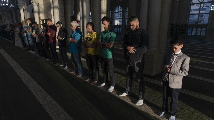 Muslims offer prayers during the first day of Eid al-Fitr, which marks the end of the holy month of Ramadan at Fatih Mosque in Istanbul, Thursday, May 13, 2021. Hundreds of Muslims attended dawn Eid al-Fitr prayers Thursday marking the end of a month of prayer and fasting for Muslims around the world, a usually joyous three-day celebration that has been significantly toned down as coronavirus cases soar. (AP Photo/Emrah Gurel)