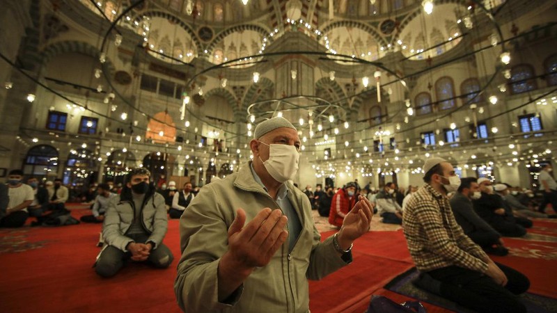 Muslims offer prayers during the first day of Eid al-Fitr, which marks the end of the holy month of Ramadan at Fatih Mosque in Istanbul, Thursday, May 13, 2021. Hundreds of Muslims attended dawn Eid al-Fitr prayers Thursday marking the end of a month of prayer and fasting for Muslims around the world, a usually joyous three-day celebration that has been significantly toned down as coronavirus cases soar. (AP Photo/Emrah Gurel)