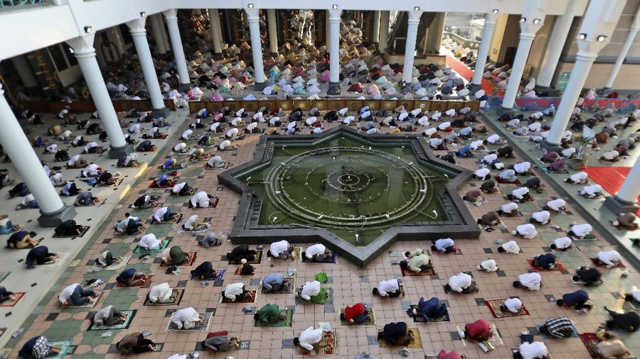 Muslims pray spaced apart to help curb the spread of coronavirus outbreak during an Eid al-Fitr prayer marking the end of Ramadan at Al Akbar mosque in Surabaya, East Java, Indonesia, Thursday, May 13, 2021. Muslims celebrated the holiday in a subdued mood for a second year Thursday as the COVID-19 pandemic again forced mosque closings and family separations on the holiday marking the end of Islam's holiest month of Ramadan. (AP Photo/Trisnadi)