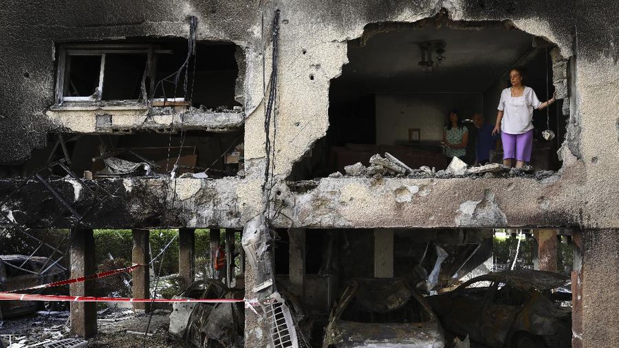 Members of Sror family inspect the damage of their apartment after it was hit by a rocket fired from the Gaza Strip over night in Petah Tikva, central Israel, Thursday, May 13, 2021. (AP Photo/Oded Balilty)