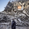 A Palestinian man looks at the destruction of a building hit by Israeli airstrikes in Gaza City, Thursday, May 13, 2021. Gaza braced for more Israeli airstrikes and communal violence raged across Israel after weeks of protests and violence in Jerusal