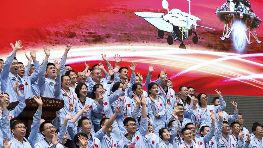 In this photo released by Xinhua News Agency, members at the Beijing Aerospace Control Center celebrate after China's Tianwen-1 probe successfully landed on Mars, at the center in Beijing, Saturday, May 15, 2021. China landed a spacecraft on Mars for the first time on Saturday, a technically challenging feat more difficult than a moon landing, in the latest advance for its ambitious goals in space. (Jin Liwang/Xinhua via AP)