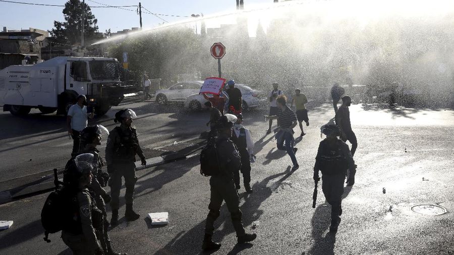 Israeli police deploy a water cannon to disperse protesters in the Sheikh Jarrah neighborhood of east Jerusalem, where several Palestinian families are under imminent threat of forcible eviction from their homes, Friday, May 14, 2021. (AP Photo/ Mahmoud Illean)