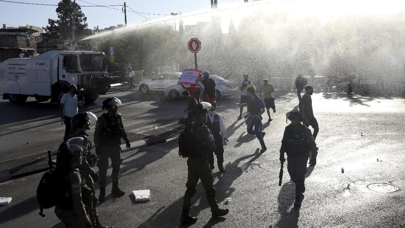Israeli police deploy a water cannon to disperse protesters in the Sheikh Jarrah neighborhood of east Jerusalem, where several Palestinian families are under imminent threat of forcible eviction from their homes, Friday, May 14, 2021. (AP Photo/ Mahmoud Illean)