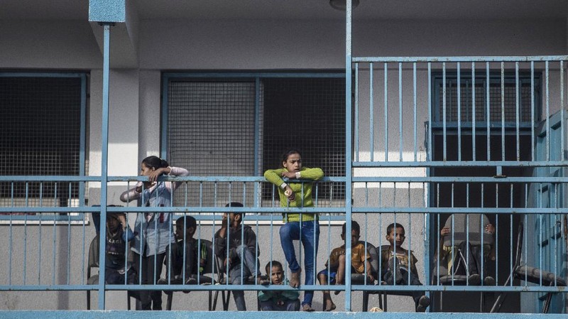 Palestinians flee their homes to a U.N. school after overnight Israeli heavy missile strikes on their neighborhoods in the outskirts of Gaza City, Friday, May 14, 2021. (AP Photo/Khalil Hamra)