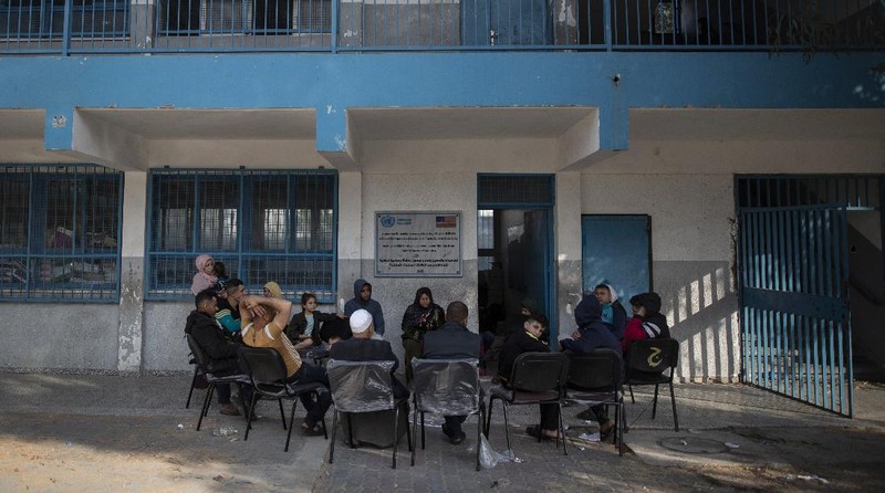 Palestinians flee their homes to a U.N. school after overnight Israeli heavy missile strikes on their neighborhoods in the outskirts of Gaza City, Friday, May 14, 2021. (AP Photo/Khalil Hamra)