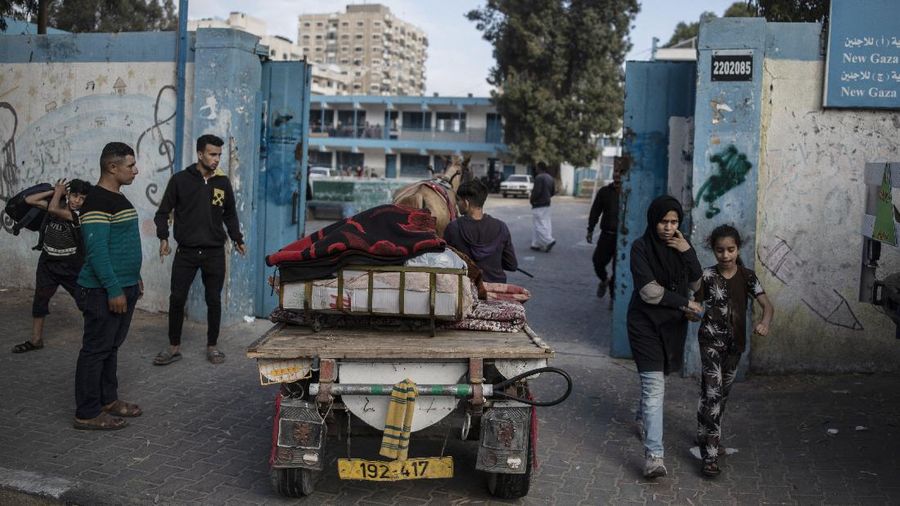Palestinians flee their homes to a U.N. school after overnight Israeli heavy missile strikes on their neighborhoods in the outskirts of Gaza City, Friday, May 14, 2021. (AP Photo/Khalil Hamra)