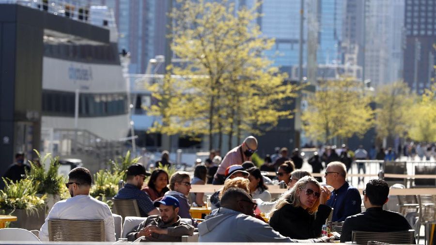 People enjoy their time in an outside sitting area of a restaurant in Chicago's Navy Pier Friday, May 14, 2021. The U.S. Centers for Disease Control and Prevention eased its guidelines on the wearing of masks outdoors, saying fully vaccinated Americans don't need to cover their faces anymore unless they are in a big crowd of strangers. (AP Photo/Shafkat Anowar)