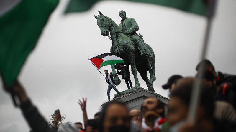 Demonstrators holding flags stand on the top of a building during a protest outside Israeli Consulate against Israel and in support of Palestinians, Saturday, May 15, 2021 in the Westwood section of Los Angeles. (AP Photo/Ringo H.W. Chiu)