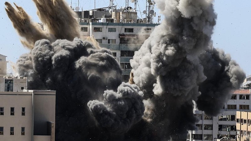 Smoke billows from a building housing various international media, including The Associated Press, after an Israeli airstrike on Saturday, May 15, 2021 in Gaza City.  The attack came roughly an hour after the Israeli military ordered people to evacuate the building, which also housed Al-Jazeera and a number of offices and apartments. There was no immediate explanation for why the building was targeted.  (Mahmud Hams /Pool Photo via AP)