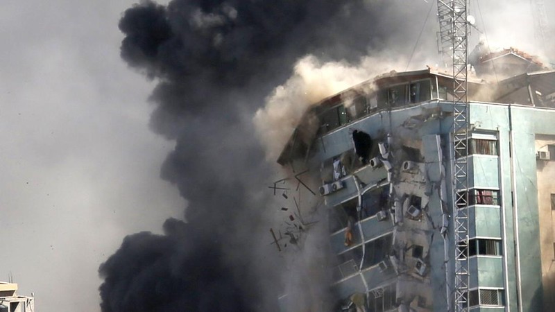 Smoke billows from a building housing various international media, including The Associated Press, after an Israeli airstrike on Saturday, May 15, 2021 in Gaza City.  The attack came roughly an hour after the Israeli military ordered people to evacuate the building, which also housed Al-Jazeera and a number of offices and apartments. There was no immediate explanation for why the building was targeted.  (Mahmud Hams /Pool Photo via AP)