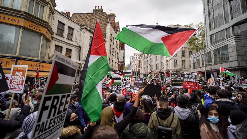 Demonstrators holding flags stand on the top of a building during a protest outside Israeli Consulate against Israel and in support of Palestinians, Saturday, May 15, 2021 in the Westwood section of Los Angeles. (AP Photo/Ringo H.W. Chiu)