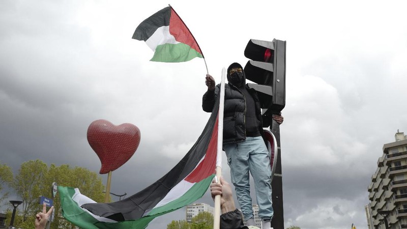 Demonstrators holding flags stand on the top of a building during a protest outside Israeli Consulate against Israel and in support of Palestinians, Saturday, May 15, 2021 in the Westwood section of Los Angeles. (AP Photo/Ringo H.W. Chiu)