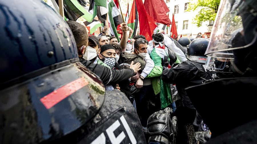 Demonstrators holding flags stand on the top of a building during a protest outside Israeli Consulate against Israel and in support of Palestinians, Saturday, May 15, 2021 in the Westwood section of Los Angeles. (AP Photo/Ringo H.W. Chiu)