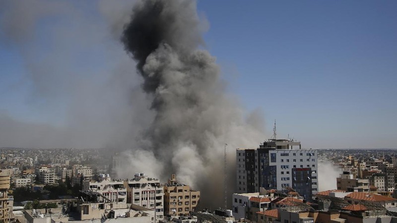 Smoke billows from a building housing various international media, including The Associated Press, after an Israeli airstrike on Saturday, May 15, 2021 in Gaza City.  The attack came roughly an hour after the Israeli military ordered people to evacuate the building, which also housed Al-Jazeera and a number of offices and apartments. There was no immediate explanation for why the building was targeted.  (Mahmud Hams /Pool Photo via AP)