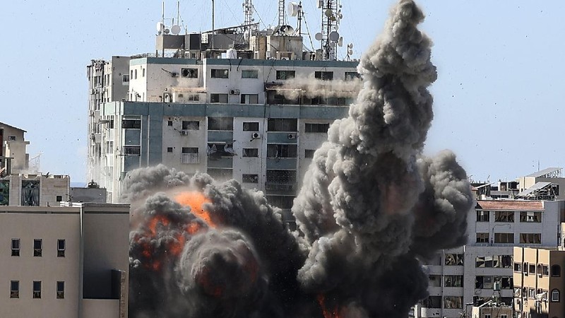 Smoke billows from a building housing various international media, including The Associated Press, after an Israeli airstrike on Saturday, May 15, 2021 in Gaza City.  The attack came roughly an hour after the Israeli military ordered people to evacuate the building, which also housed Al-Jazeera and a number of offices and apartments. There was no immediate explanation for why the building was targeted.  (Mahmud Hams /Pool Photo via AP)