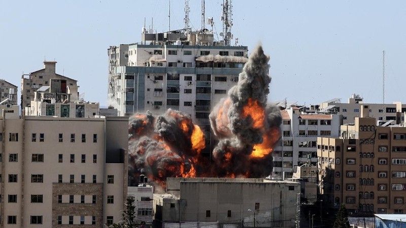 Smoke billows from a building housing various international media, including The Associated Press, after an Israeli airstrike on Saturday, May 15, 2021 in Gaza City.  The attack came roughly an hour after the Israeli military ordered people to evacuate the building, which also housed Al-Jazeera and a number of offices and apartments. There was no immediate explanation for why the building was targeted.  (Mahmud Hams /Pool Photo via AP)