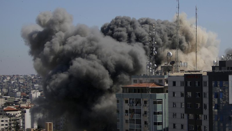 Smoke billows from a building housing various international media, including The Associated Press, after an Israeli airstrike on Saturday, May 15, 2021 in Gaza City.  The attack came roughly an hour after the Israeli military ordered people to evacuate the building, which also housed Al-Jazeera and a number of offices and apartments. There was no immediate explanation for why the building was targeted.  (Mahmud Hams /Pool Photo via AP)