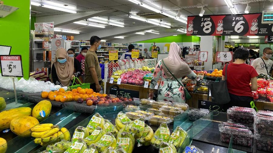 People wear masks and observe social distancing while lining up to pay at a supermarket in Singapore, Friday, May 14, 2021. Singapore further tightened its COVID-19 measures as it sought to control an increase in untraceable coronavirus infections in the city-state. (AP Photo/Zen Soo