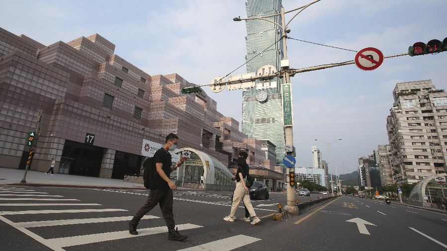 People wear face masks to protect against the spread of the coronavirus and walk past Taipei 101 building after the COVID-19 alert raise to level 3 in Taipei, Taiwan, Saturday, May 15, 2021. Taiwan, which has had enviable success in containing COVID-19, imposed new restrictions in its capital city on Saturday as it battled its worst outbreak since the pandemic began. (AP Photo/Chiang Ying-ying)