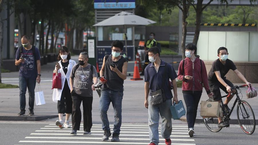 People wear face masks to protect against the spread of the coronavirus after the COVID-19 alert raise to level 3 in Taipei, Taiwan, Saturday, May 15, 2021. Taiwan, which has had enviable success in containing COVID-19, imposed new restrictions in its capital city on Saturday as it battled its worst outbreak since the pandemic began. (AP Photo/Chiang Ying-ying)