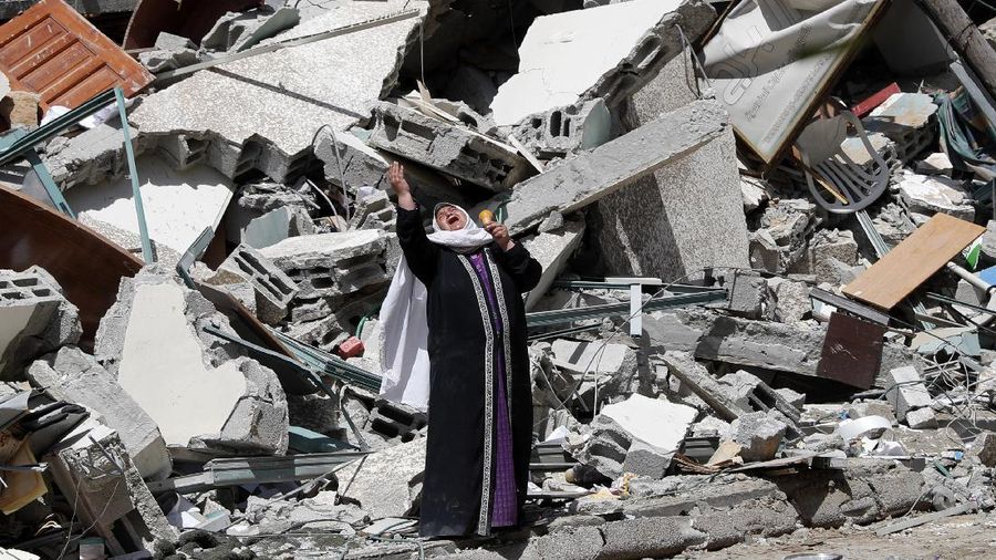 A woman reacts while standing near the rubble of a building that was destroyed by an Israeli airstrike on Saturday that housed The Associated Press, broadcaster Al-Jazeera and other media outlets, in Gaza City, Sunday, May 16, 2021. (AP Photo/Adel Hana)