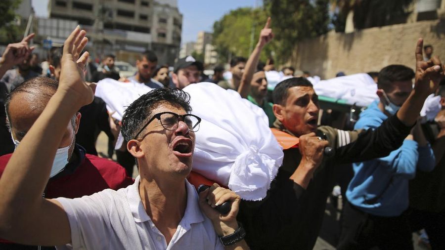 Mourners carry the the bodies of Palestinians who were killed in overnight Israeli airstrikes that hit their homes, during their funeral in Gaza City, Sunday, May 16, 2021. (AP Photo/Abdel Kareem Hana)