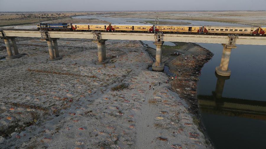 Several bodies are seen buried in shallow graves on the banks of Ganges river in Prayagraj, India. Saturday, May 15, 2021. Police are reaching out to villagers in northern India to investigate the recovery of bodies buried in shallow sand graves or washing up on the Ganges River banks, prompting speculation on social media that they were the remains of COVID-19 victims. (AP Photo/Rajesh Kumar Singh)
