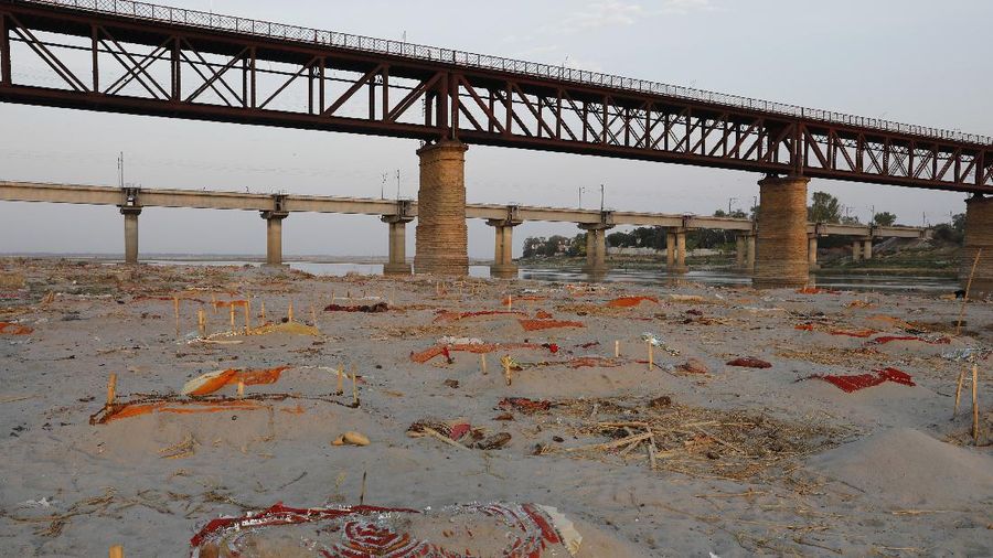 Bodies of suspected Covid-19 victims are seen in shallow graves buried in the sand near a cremation ground on the banks of Ganges River in Prayagraj, India, Saturday, May 15, 2021. (AP Photo/Rajesh Kumar Singh)