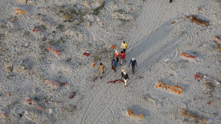 Bodies of suspected Covid-19 victims are seen in shallow graves buried in the sand near a cremation ground on the banks of Ganges River in Prayagraj, India, Saturday, May 15, 2021. (AP Photo/Rajesh Kumar Singh)