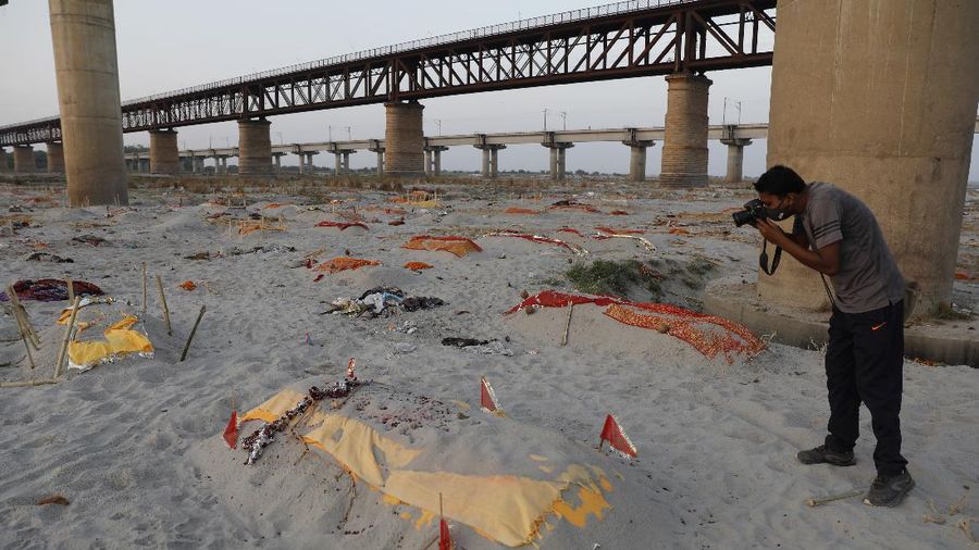 Bodies of suspected Covid-19 victims are seen in shallow graves buried in the sand near a cremation ground on the banks of Ganges River in Prayagraj, India, Saturday, May 15, 2021. (AP Photo/Rajesh Kumar Singh)