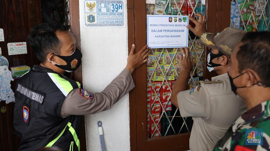 Gugus tugas Kelurahan Lenteng Agung memasangkan stiker tanda sedang menjalani isolasi mandir terhadap rumah pemudik yang baru balik ke Jakarta di kawasan Lenteng Agung, Jakarta, Senin, 17 Mei 2021. Pemerintah Kota Jakarta Selatan menginstruksikan setiap kelurahan untuk menempelkan stiker bertuliskan “pendatang mudik ini sedang menjalani isolasi mandiri 14 hari” di hunian pemudik yang baru datang dari kampung halaman. Hal itu dilakukan sebagai antisipasi arus balik pemudik dan menekan penyebaran Covid-19. 