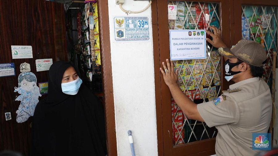 Gugus tugas Kelurahan Lenteng Agung memasangkan stiker tanda sedang menjalani isolasi mandir terhadap rumah pemudik yang baru balik ke Jakarta di kawasan Lenteng Agung, Jakarta, Senin, 17 Mei 2021. Pemerintah Kota Jakarta Selatan menginstruksikan setiap kelurahan untuk menempelkan stiker bertuliskan “pendatang mudik ini sedang menjalani isolasi mandiri 14 hari” di hunian pemudik yang baru datang dari kampung halaman. Hal itu dilakukan sebagai antisipasi arus balik pemudik dan menekan penyebaran Covid-19. 