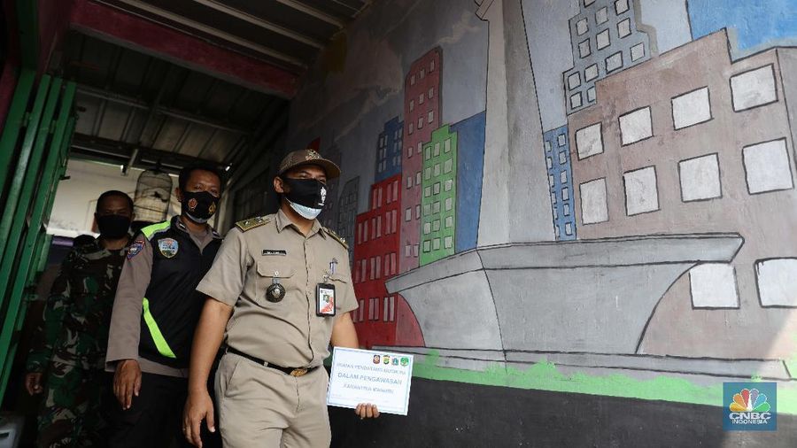 Gugus tugas Kelurahan Lenteng Agung memasangkan stiker tanda sedang menjalani isolasi mandir terhadap rumah pemudik yang baru balik ke Jakarta di kawasan Lenteng Agung, Jakarta, Senin, 17 Mei 2021. Pemerintah Kota Jakarta Selatan menginstruksikan setiap kelurahan untuk menempelkan stiker bertuliskan “pendatang mudik ini sedang menjalani isolasi mandiri 14 hari” di hunian pemudik yang baru datang dari kampung halaman. Hal itu dilakukan sebagai antisipasi arus balik pemudik dan menekan penyebaran Covid-19. 