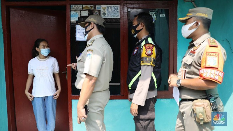 Gugus tugas Kelurahan Lenteng Agung memasangkan stiker tanda sedang menjalani isolasi mandir terhadap rumah pemudik yang baru balik ke Jakarta di kawasan Lenteng Agung, Jakarta, Senin, 17 Mei 2021. Pemerintah Kota Jakarta Selatan menginstruksikan setiap kelurahan untuk menempelkan stiker bertuliskan “pendatang mudik ini sedang menjalani isolasi mandiri 14 hari” di hunian pemudik yang baru datang dari kampung halaman. Hal itu dilakukan sebagai antisipasi arus balik pemudik dan menekan penyebaran Covid-19. 